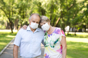 elderly couple wearing medical face mask in the summer garden. health concept. Corona Virus.