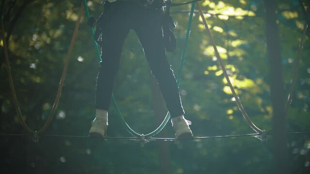 A woman walking on the rope - an entertainment attraction in the forest