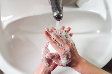 Fototapeta premium Man washing hands to protect against the coronavirus
