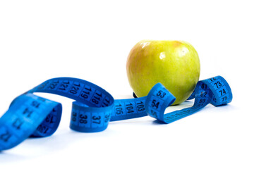 green Apple and measuring tape on a white background, weight loss and healthy lifestyle