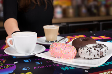 Young girl issues an order of coffee and sweet donuts