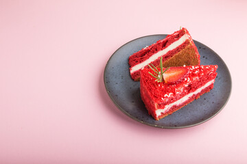 Homemade red velvet cake with milk cream and strawberry on blue ceramic plate isolated on a pink pastel background. side view, copy space.