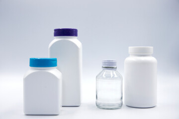 White plastic glass bottle for pill or food supplement studio photo on white background. Pharmacologic container mockup. Pill or drug jar blank package design. Clean pack for medicine diet vitamin