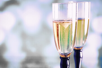 Background with tall glasses for sparkling wines. Champagne and spray in glass glasses. Celebratory drink with reflection.
