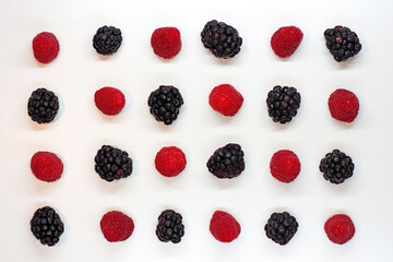 High angle view from directly above of 24 alternatively orderly arranged blackberries and raspberries