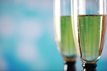 Background with tall glasses for sparkling wines. Champagne and spray in glass glasses. Celebratory drink with reflection.