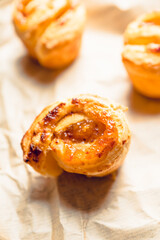 Fresh sweet bun with orange jam on the rustic wooden background. Selective focus. 