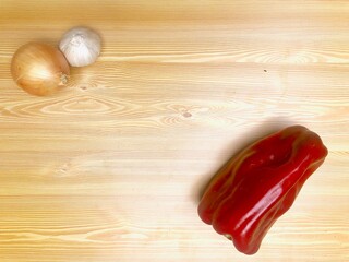 PImiento, ajo y cebolla sobre fondo de madera clara. Receta de cocina.