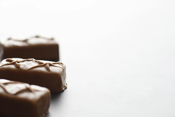 Chocolate bars on a black background in backlight. Chocolate with filling. Sweet sweets for snack and tea.