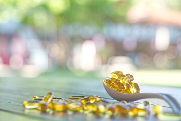 Capsules fish oil omega-3 on a white spoon. Health and beauty concept.