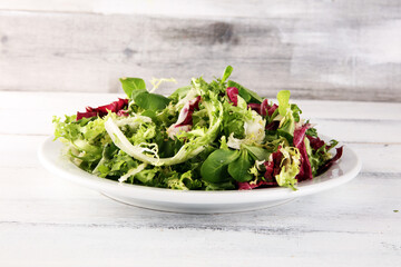 Mix fresh leaves of arugula, lettuce, spinach, beets for salad on table