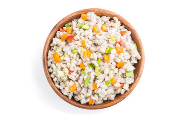 Pearl barley porridge with vegetables in wooden bowl isolated on white background. Top view, close up.