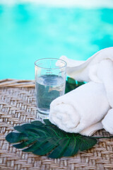 pool and sunbathing accessories. Glass of water, towel Copy space
