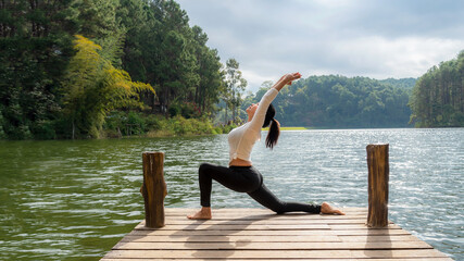 Fototapeta na wymiar Healthy Yoga woman lifestyle balanced practicing meditate and energy yoga on the bridge in morning and sunset outdoors nature.