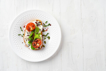 Sandwich with soft cheese and sliced tomatoes