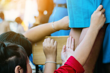 Female students are helping to wipe the glass with wet newspaper at school.