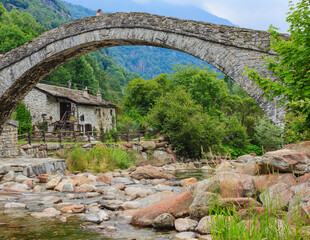  a   characteristic  bridge  of a piedmontese alpine village /a romanesque bridge made of donkey back of  of the 17th century, at the entrance to the village of Fondo ,in Piedmont,Italy