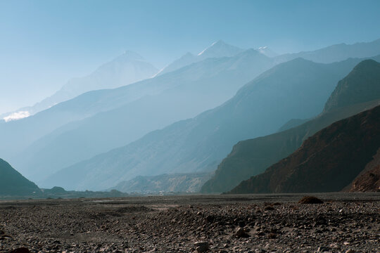 View of mountains near muktinath temple at mustang, Nepal. Blue sky sunny day and more mountains far away hidden amongst the fog.