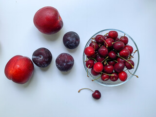 Peaches, nectarines, plums and cherries on a white background.  Summer refreshing food. Healthy food, vegetarianism, vitamins.