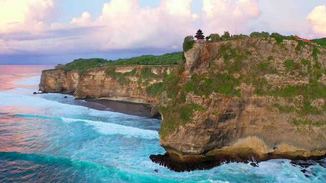 Bali - Aerial 4k footage of Pura Luhur temple in Uluwatu. Cliffs and ocean from above in sunset.	
