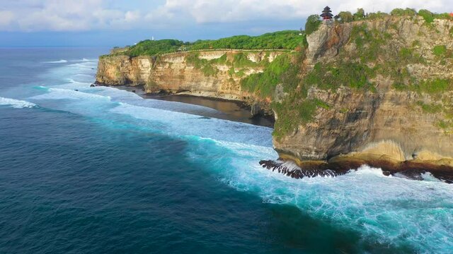 Bali - Aerial 4k footage of Pura Luhur temple in Uluwatu. Cliffs and ocean from above in sunset.	
