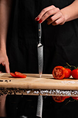 Closeup of hands of chef cook cutting vegetables on wooden table