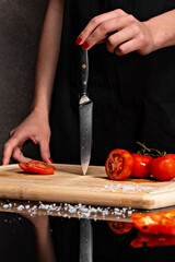 Closeup of hands of chef cook cutting vegetables on wooden table