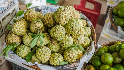 Fruits at the market. Annona squamosa. sugar-apples or sweetsops with oranges in Vietnam. Tropical fruit. Harvest and commerce concept.