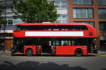 Een moderne Londense dubbeldekkerbus, gezien vanaf de linkerkant, met open deuren.