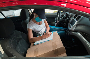 A woman with face mask sorting boxes for delivery