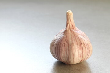 The raw garlic is on the grey table