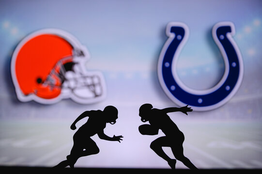 Cleveland Browns vs. Indianapolis Colts. NFL match poster. Two american football players silhouette facing each other on the field. Clubs logo in background. Rivalry concept photo.
