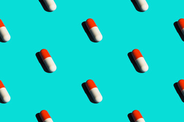 Seamless pattern diagonal rows of white and red pills in capsules with drop shadow on blue background. Healthcare disease treatment drugs medical concept