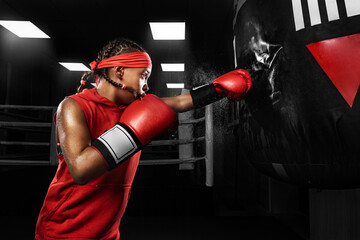 Kids sport concept. Girl sportsman muay thai boxer fighting in gloves in boxing gym.