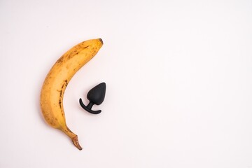 Closeup shot of a banana and an anal plug isolated on a white background