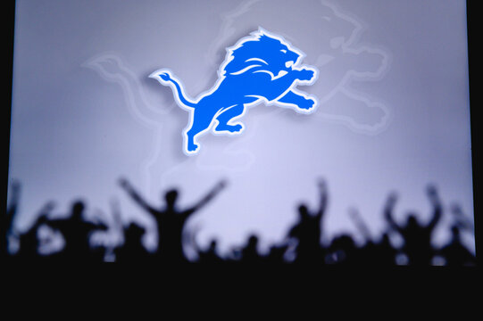 Detroit Lions. Fans support professional team of American National Foorball League. Silhouette of supporters in foreground. Logo on the big screen.