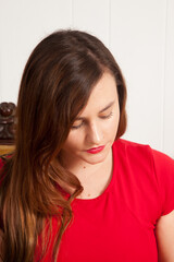 Fototapeta premium Pretty woman sitting on a Gold Couch looking thoughtful