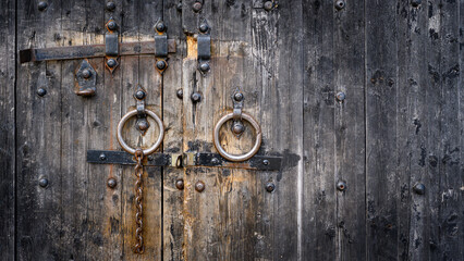 Old rusty lock bolt on antique wooden door gates.