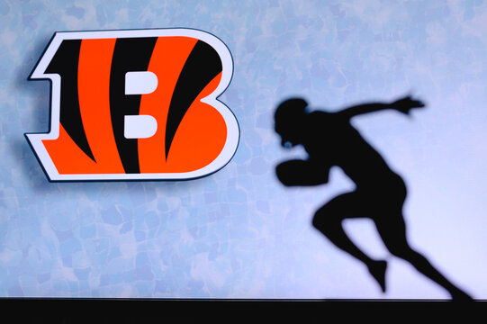 Cincinnati Bengals. Silhouette Of Professional American Football Player. Logo Of NFL Club In Background, Edit Space.