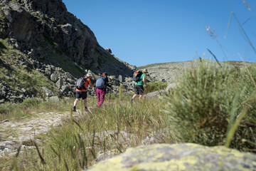 Fototapeta na wymiar Three hikers climbing the Sierra de Gredos in Avila, Castilla Leon, Spain, Europe. Two men and a woman.