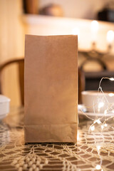 Coffee pouch mockup with coffee cup and milk on dark romantic background. Paper clear bag in candles light