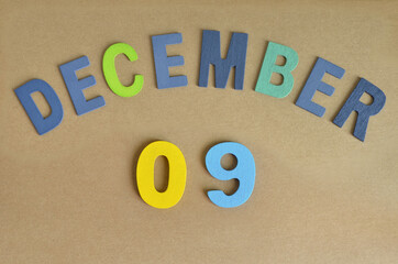 December 9, Toy alphabet with a brown background.