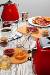 Photo of kitchen table with toasts, fruit jams and knife