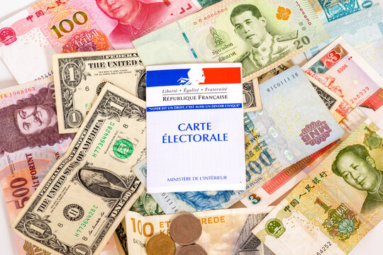 French voter registration card, electoral card, with background of international currencies. Concept photo for the influence of foreign money in French politics.