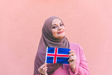 Muslim woman in hijab holds flag of  Iceland 