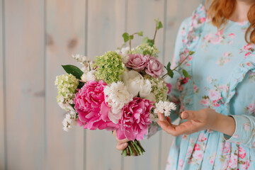 Wedding bouquet at the florist in the hands of roses peonies flowers