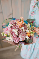 Wedding bouquet at the florist in the hands of roses peonies flowers