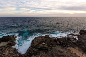 ocean waves hit and crash against stones