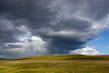 Fototapeta na wymiar Dramatic thunderclouds over the tundra illuminated by the sunlight, Finnmark, Norway