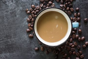 Black coffee in Blue cup on freshly roasted coffee beans background. Top view.
